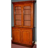 A Victorian mahogany cabinet, the flared cornice above glazed doors enclosing shelves,