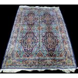 A Kirman carpet, with large panels of floral decoration, signed to upper border,