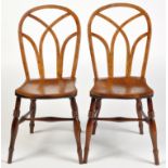 A pair of early 19th Century Windsor chairs, the low hoop backs over Gothic tracery arches,