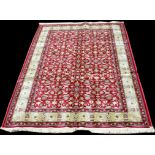 A Kashmir rug, the scrolling design on red field, 300 x 194cms (118 x 76in.).