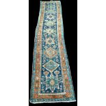 A Heriz runner, the geometric medallions on blue ground, 474 x 87cms (186 1/2 x 34in.).