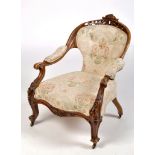 A Victorian carved walnut nursing chair, with pierced scrolling cresting rail above button back,