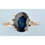 A sapphire and diamond ring, the oval facet cut sapphire flanked by brilliant cut diamonds,