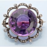An Edwardian amethyst and diamond brooch, the circular facet cut amethyst weighing approximately 20.