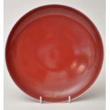 Chinese 'peach bloom' saucer dish, the slightly speckled glaze of graduated colour towards the rim,