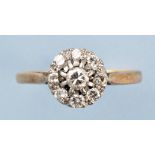 A diamond cluster ring, set with nine brilliant cut diamonds above chenier shoulders,