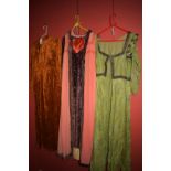 Medieval style costume gowns in green, brown and pink, one with bonnet.