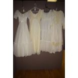 Four white dresses various, one with hooped petticoat.