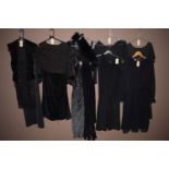 Ladies dresses in black of various styles and material, one with glitter decoration.