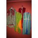 Medieval style costume in green, blue red and floral patterns.