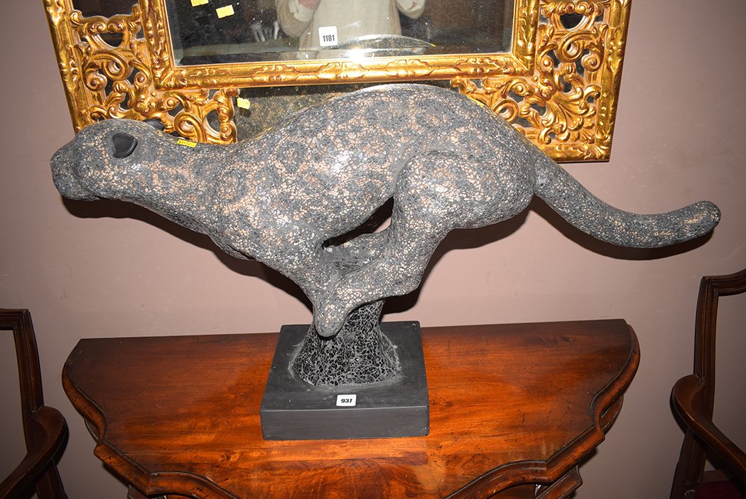 A modern cast sculpture of a running cheetah, raised on square plinth base.