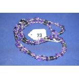 An amethyst and magnetic black stone necklace.