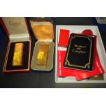 A Cartier gold-plated lighter; and a Dunhill gold-plated lighter;