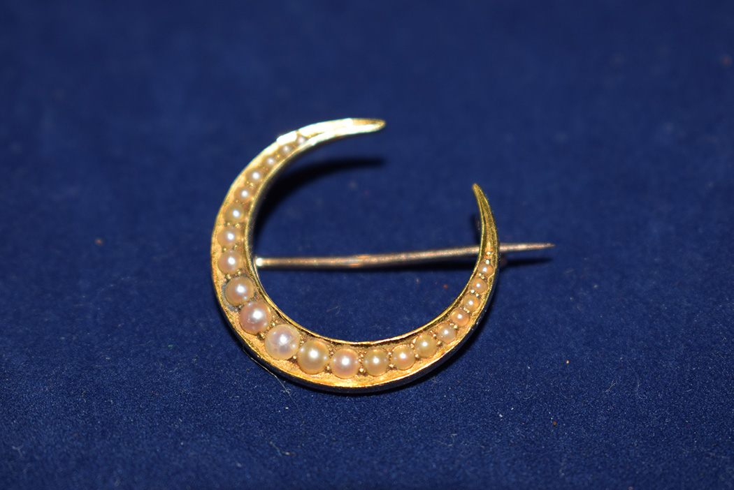 A Victorian 15ct. yellow gold crescent brooch set seed pearls.