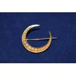 A Victorian 15ct. yellow gold crescent brooch set seed pearls.