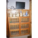A 20th Century oak bookcase, with eight lead glazed lift-up doors,