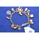 A 9ct yellow gold chain link charm bracelet with fifteen charms, 22.1grms.