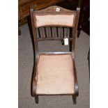 An Edwardian inlaid rosewood easy chair, the back and seat upholstered in pink material.