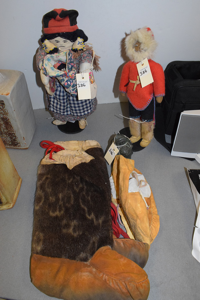 A pair of Eskimo Inuit fur boots; moccasins; a carving; and two dolls on stands.