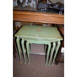 A 20th Century nest of green painted tables, floral and gilt decoration.