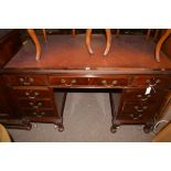 A reproduction stained wood kneehole desk,