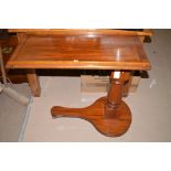 A 20th Century mahogany bed table, the tilting top with raising action, 81.5cms wide.