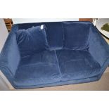 A two-seater sofa bed upholstered in blue velour material.