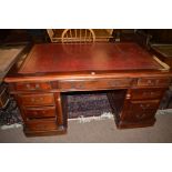 A 20th Century mahogany partners knee hole desk inset red leather top,