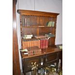 An early 20th Century oak dresser delft rack above associated base fitted two panel doors, 107.