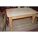 A Victorian stripped pine kitchen table, raised on on turned legs, 122cms wide.