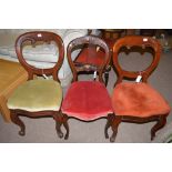A pair of Victorian mahogany balloon back dining chairs, upholstered in orange and green material,