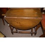 A 20th Century oak gateleg dining table, raised on barley twist legs, 90.5cms wide.