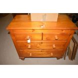 A 20th Century stained pine chest of two short and two long drawers raised on turned feet,