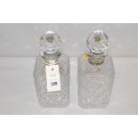 A pair of cut-crystal glass decanters with silver collars.