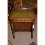 A 20th Century oak Davenport, inset green leather top opening to reveal compartments,