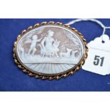 A carved shell cameo brooch set 9ct yellow gold, depicting a classical scene of a lady with a lyre.