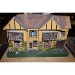 A 20th Century Tudor Revival doll's house; together with accessories.