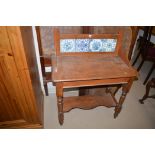 A late Victorian stained wood washstand with blue and white tile back,