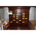 A watchmakers cabinet, containing various pocket watch accessories, to include: screwdriver blades,