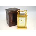 A brass carriage clock with enamel dial,