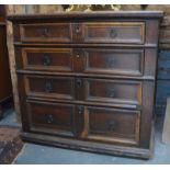 A late 17th century joined oak chest of two short over three long drawers, each with applied