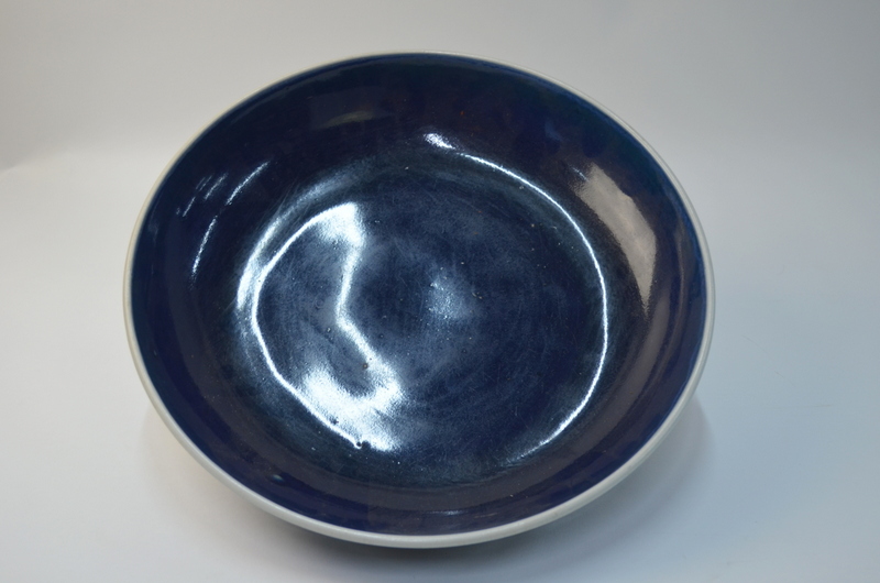 A large Chinese blue monochrome circular dish with unglazed base, 34 cm diameter,