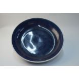 A large Chinese blue monochrome circular dish with unglazed base, 34 cm diameter,
