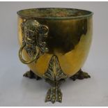 A 19th century brass ovoid log-bin with mask and ring handles, on cast claw feet