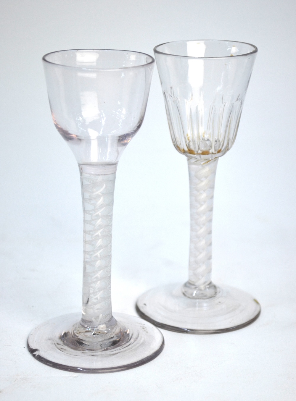 Two 18th century cordial glasses, one with round funnel moulded bowl, multiple spiral opaque twist