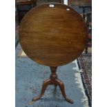 An early 19th century mahogany tea table with circular tilt-top,