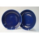 A pair of Chinese blue monochrome saucer dishes; 21 cm diameter.