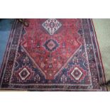 A South West Persian Shiraz rug, the central ivory lozenge on red field with flora and fauna design,