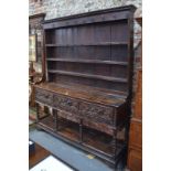 An 18th century oak dresser with plate-rack over three frieze drawers, on turned supports with pot-