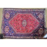 A Persian Shiraz rug, the stylised bird design in multi-colours on red ground, 192 x 135 cm